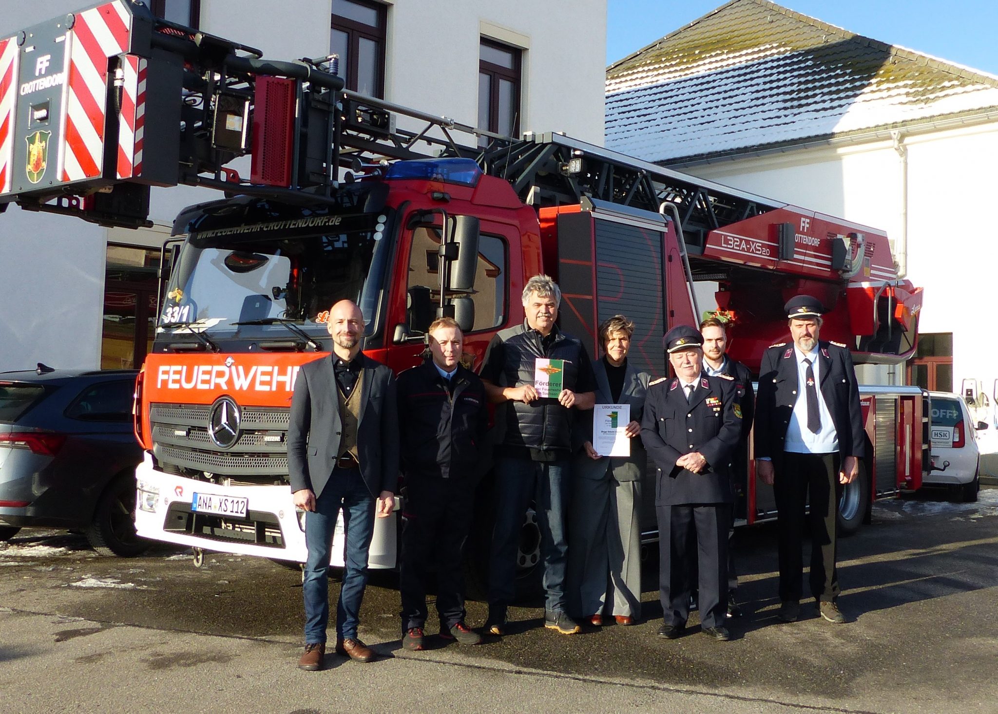 Vor der Drehleiter der Feuerwehr Crottendorf von links: Bürgermeister Sebastian Martin, Ortswehrleiter Chris Nachtigall, Geschäftsführer Jürgen Burkert, Geschäftsführerin Katrin Viertel, Siegfried Heinrich vom Kreisfeuerwehrverband Erzgebirge e.V., stellv. Ortswehrleiter Dennis Markert und stellv. Gemeindewehrleiter Uwe Markert. Foto: Anna Viertel